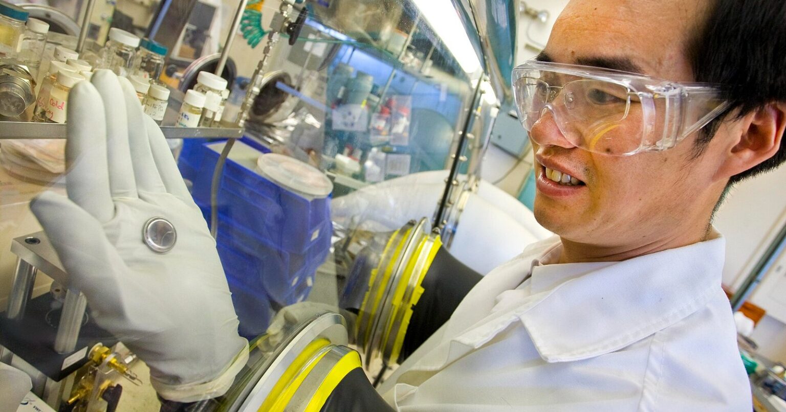 Sodium-ion hard carbon anode research: a scientist holds a coin cell battery used for electrode testing